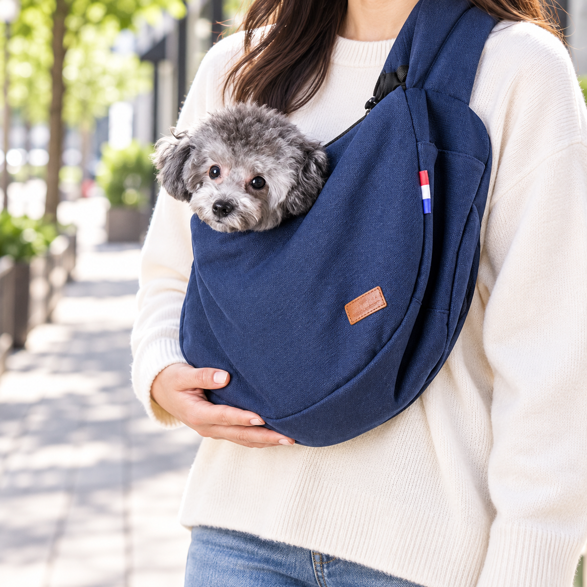 AeroCarry navy shoulder sling worn with a small gray dog inside