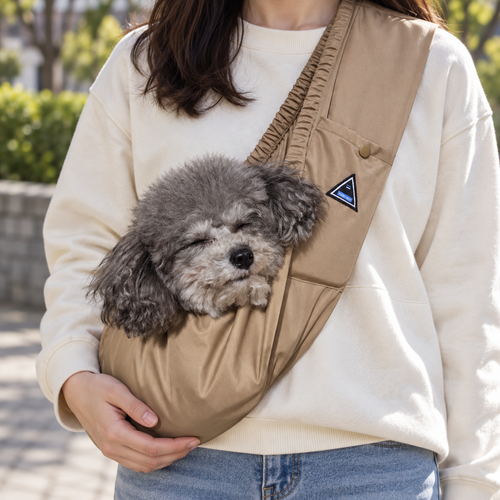AirTrail tan front sling carrier worn with a small gray dog inside